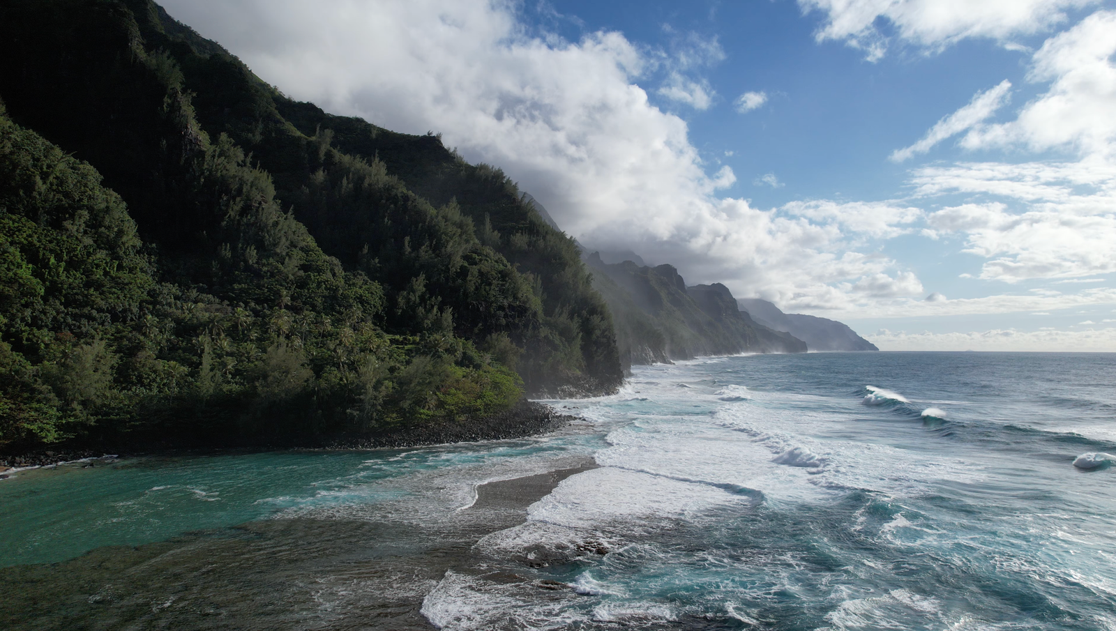 A breathtaking aerial view of Na Pali Coastline with lush cliffs and the Pacific Ocean