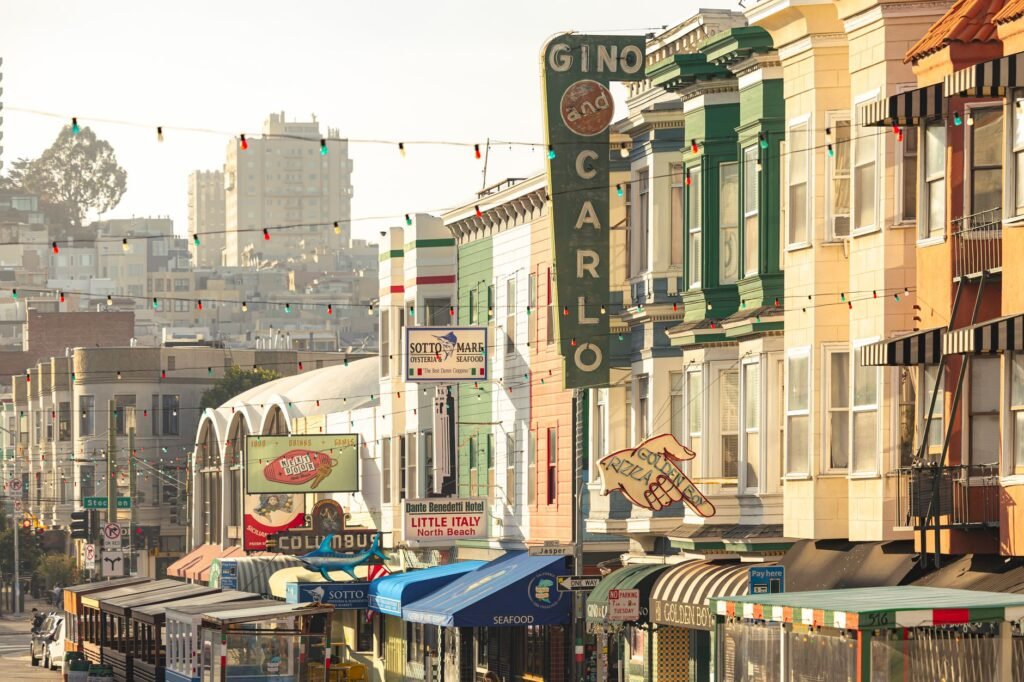 A bustling Little Italy street with colorful storefronts and pedestrians enjoying the atmosphere