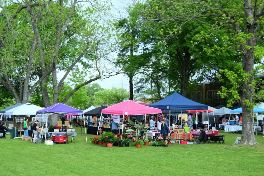 A bustling outdoor market with colorful tents and visitors in Whitehouse, Texas