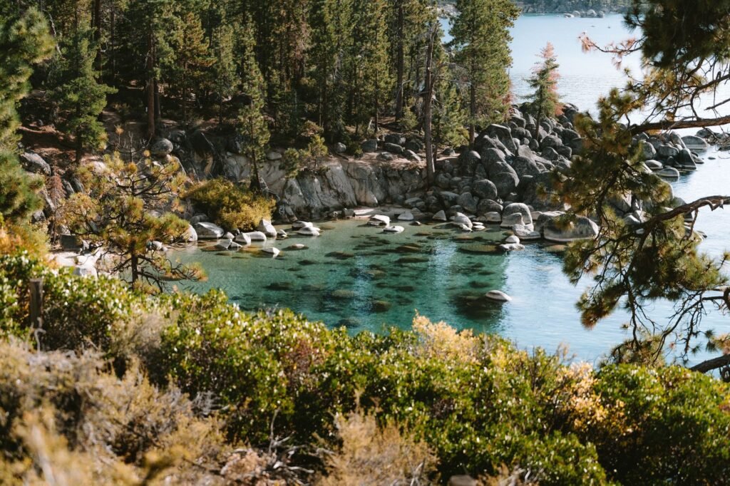 A hiker pauses on a ridge overlooking turquoise waters of North Lake Tahoe