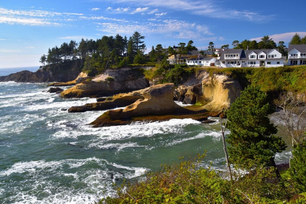 A panoramic view of Depoe Bay harbor at sunrise, showing boats and the iconic lighthouse