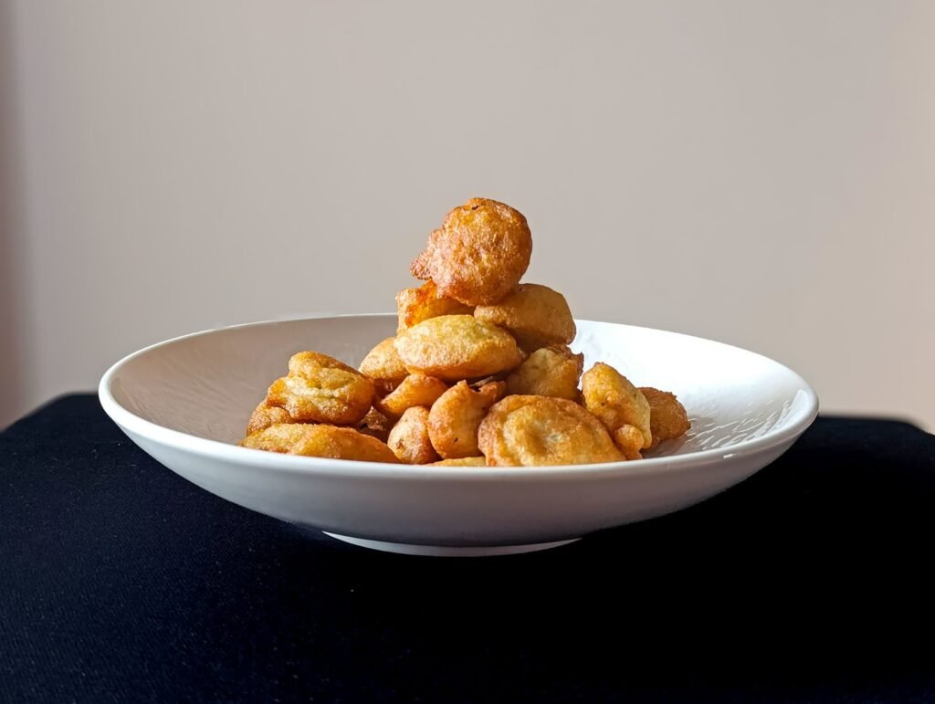 A plate of golden conch fritters served with tangy dipping sauce, a must‑try local snack