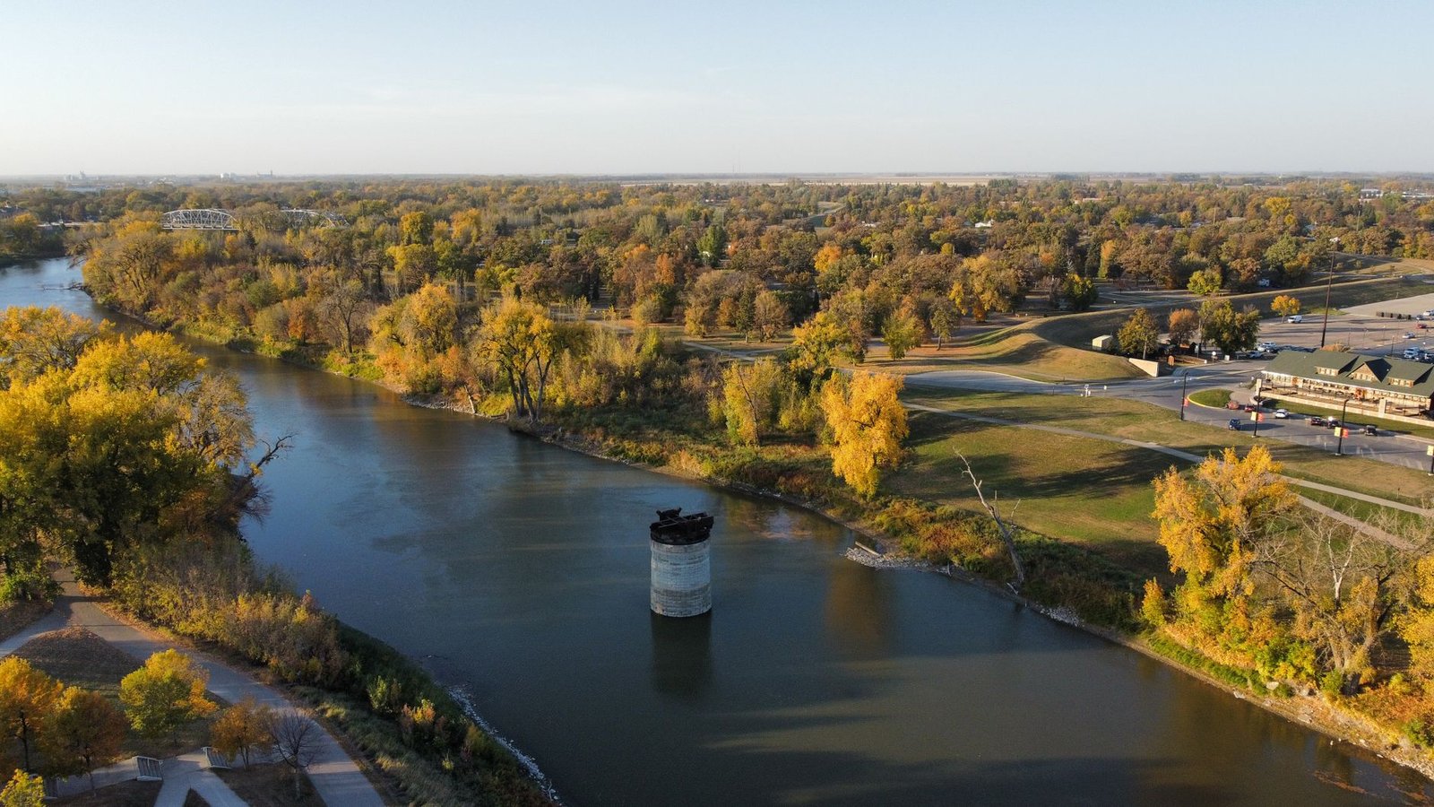 A scenic aerial view of a river surrounded by fall foliage in Grand Forks, North Dakota