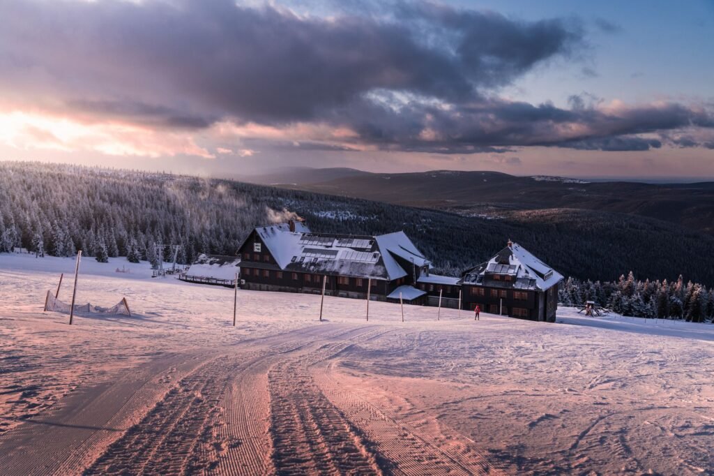 A sunrise over a bustling ski resort, highlighting fresh powder on the slopes