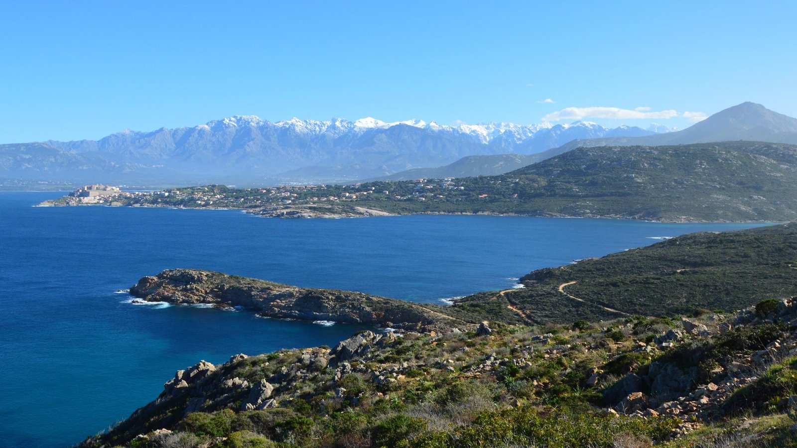 Beautiful coastline and mountainous backdrop in Calvi, Corsica, France during a clear day