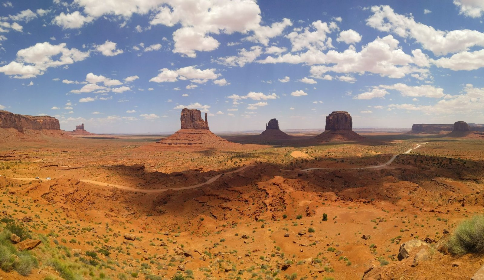 Breathtaking view of Monument Valley's iconic buttes under a blue sky with clouds