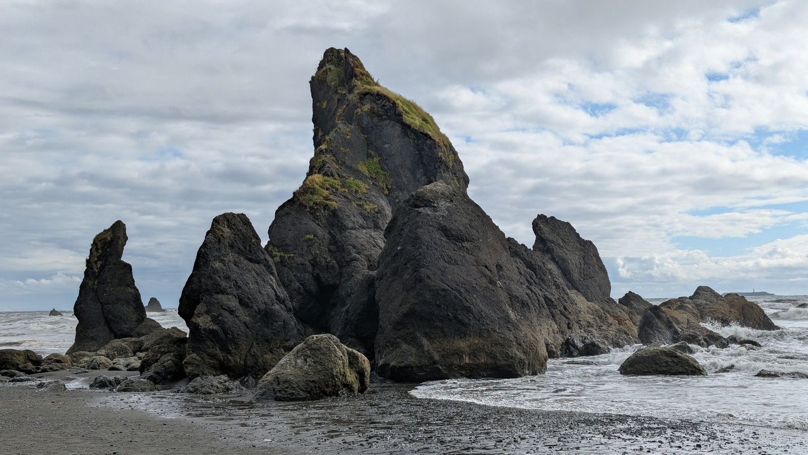 Dramatic rock formations along the coast of Washington State under a cloudy sky