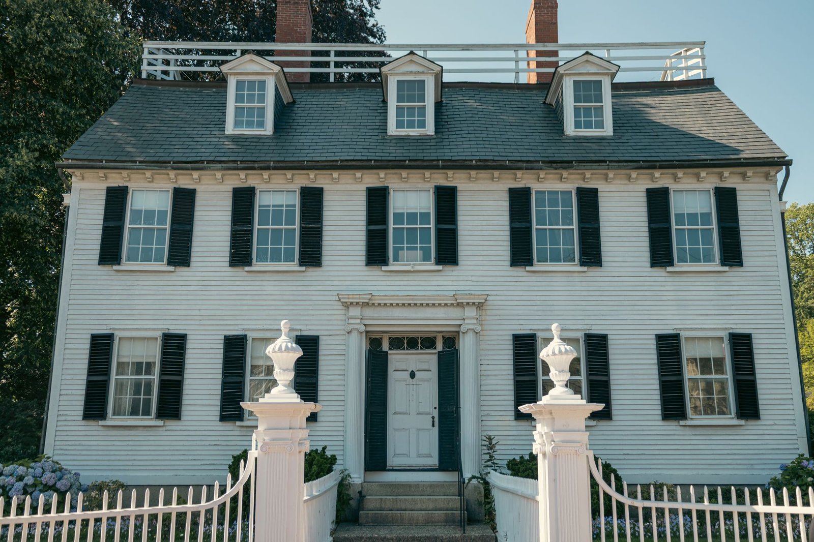 Elegant Colonial-style house with black shutters and white picket fence in Salem, Massachusetts
