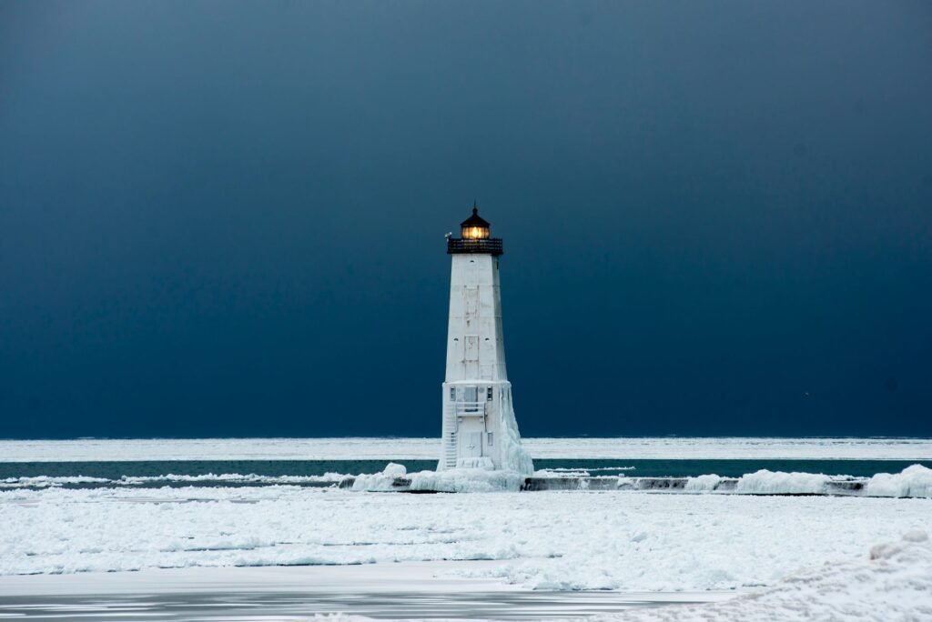 Icy Frankfort Lighthouse with dark sky in Michigan's winter landscape