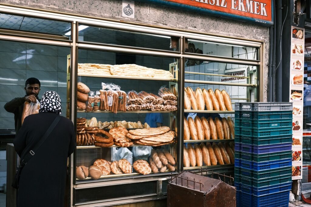 Outdoor bakery showcasing a variety of traditional breads and pastry offerings through a window display