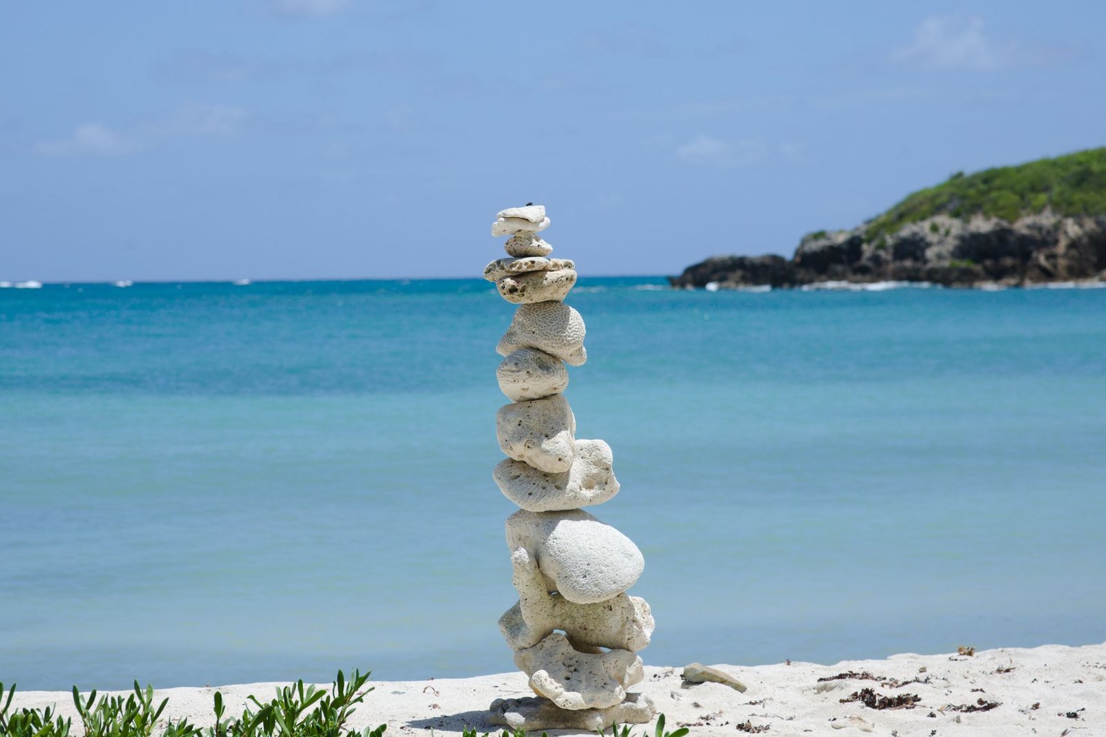 Peaceful rock stack on a sandy shore, overlooking the turquoise sea in Vieques, Puerto Rico
