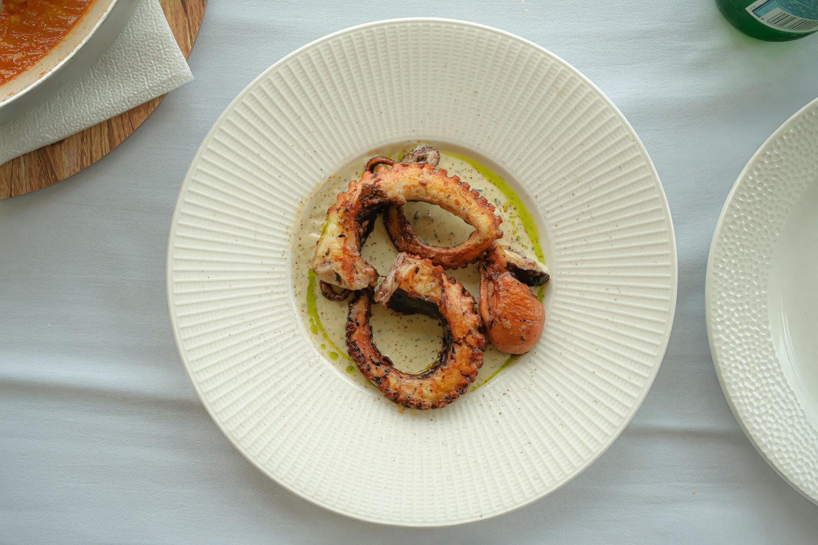 Savor traditional Greek dishes at **Taverna Katina** in Ammoudi Bay, known for its grilled octopus. Savor traditional Greek dishes at **Taverna Katina** in Ammoudi Bay, known for its grilled octopus.