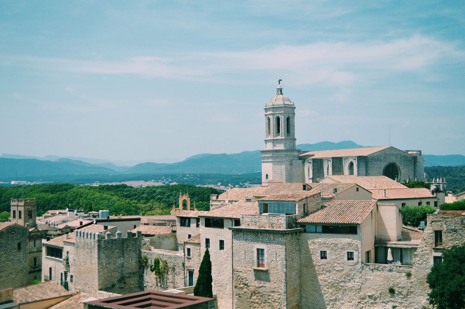 Scenic view of an old European town with a historic church, surrounded by mountains