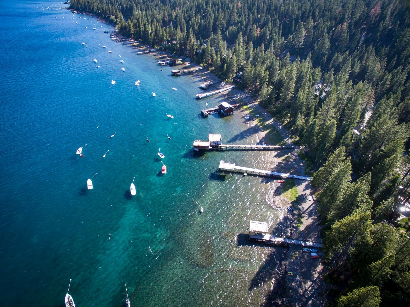 Stunning aerial shot of Lake Tahoe's forested shoreline and boats during summer
