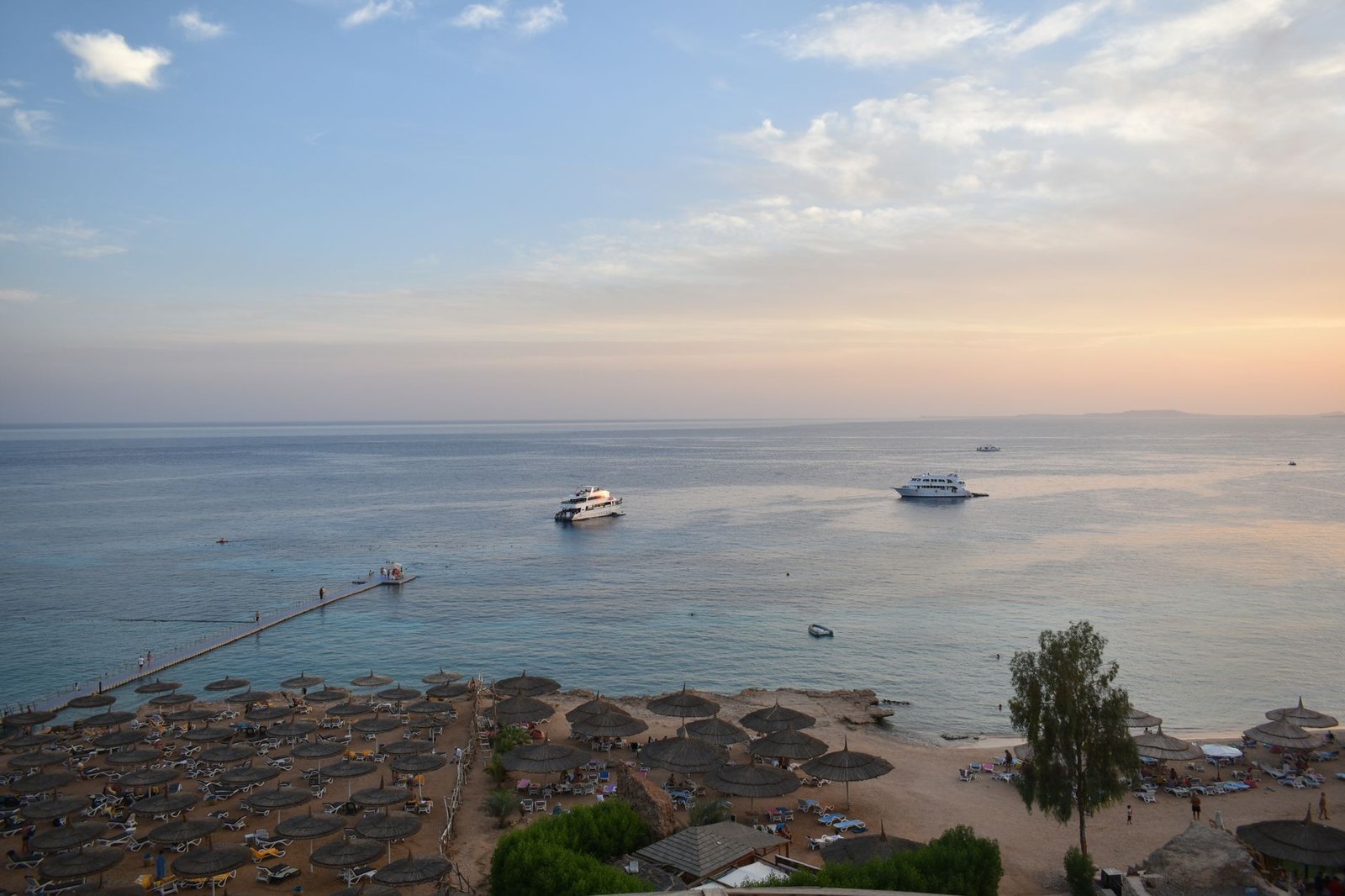 Stunning aerial view of Sharm El Sheikh's beach and sea during sunset with boats and parasols