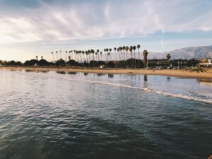 Stunning beach with palm trees and mountains at sunset