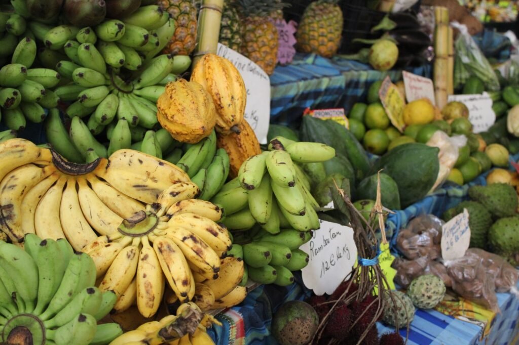 Vibrant assortment of tropical fruits including bananas and pineapples at an outdoor market